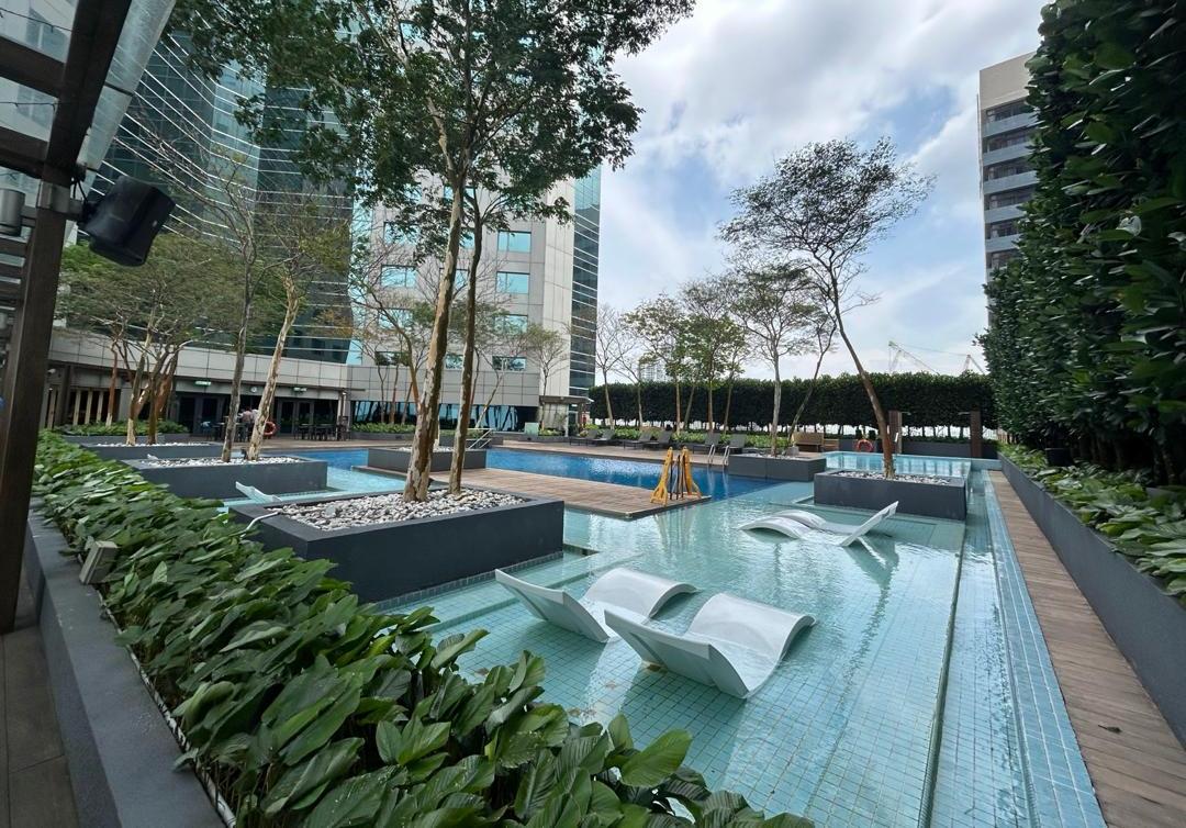 Urban courtyard pool with white wave loungers and tropical planting