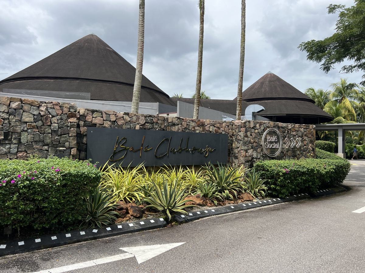 Balé Clubhouse stone entrance signage with tropical planting