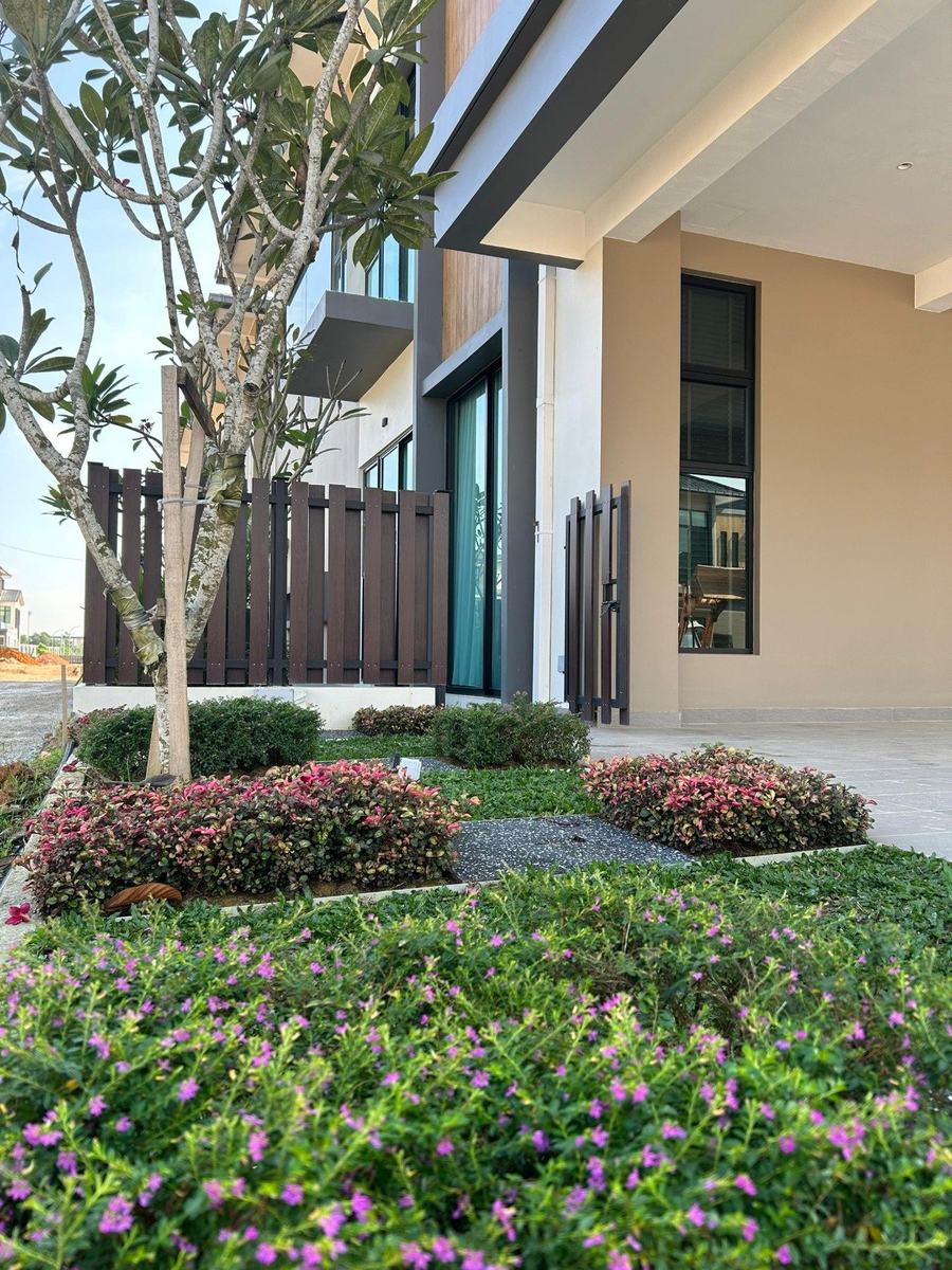 Residential show unit garden with flowering shrub beds and fence