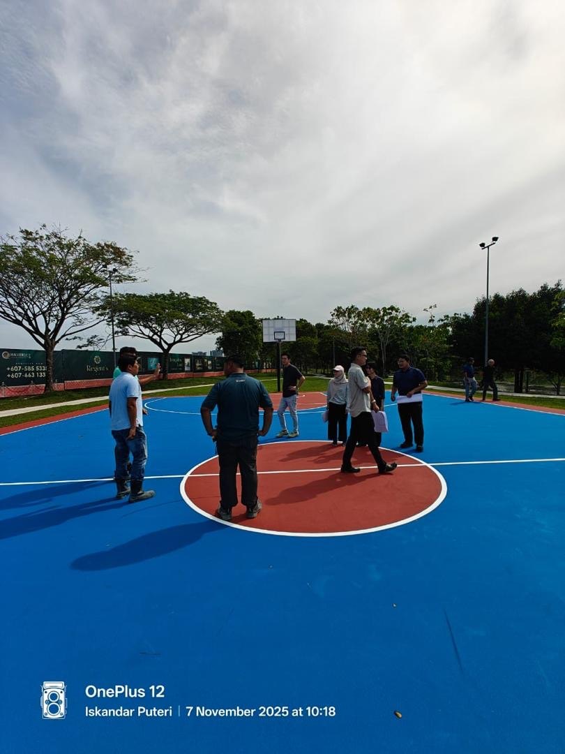Team inspecting a newly surfaced blue and red sports court