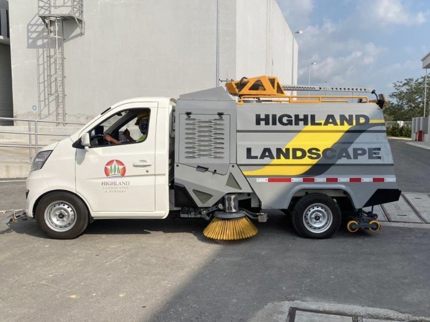 Highland Landscapes branded road sweeper and pressure-wash vehicle